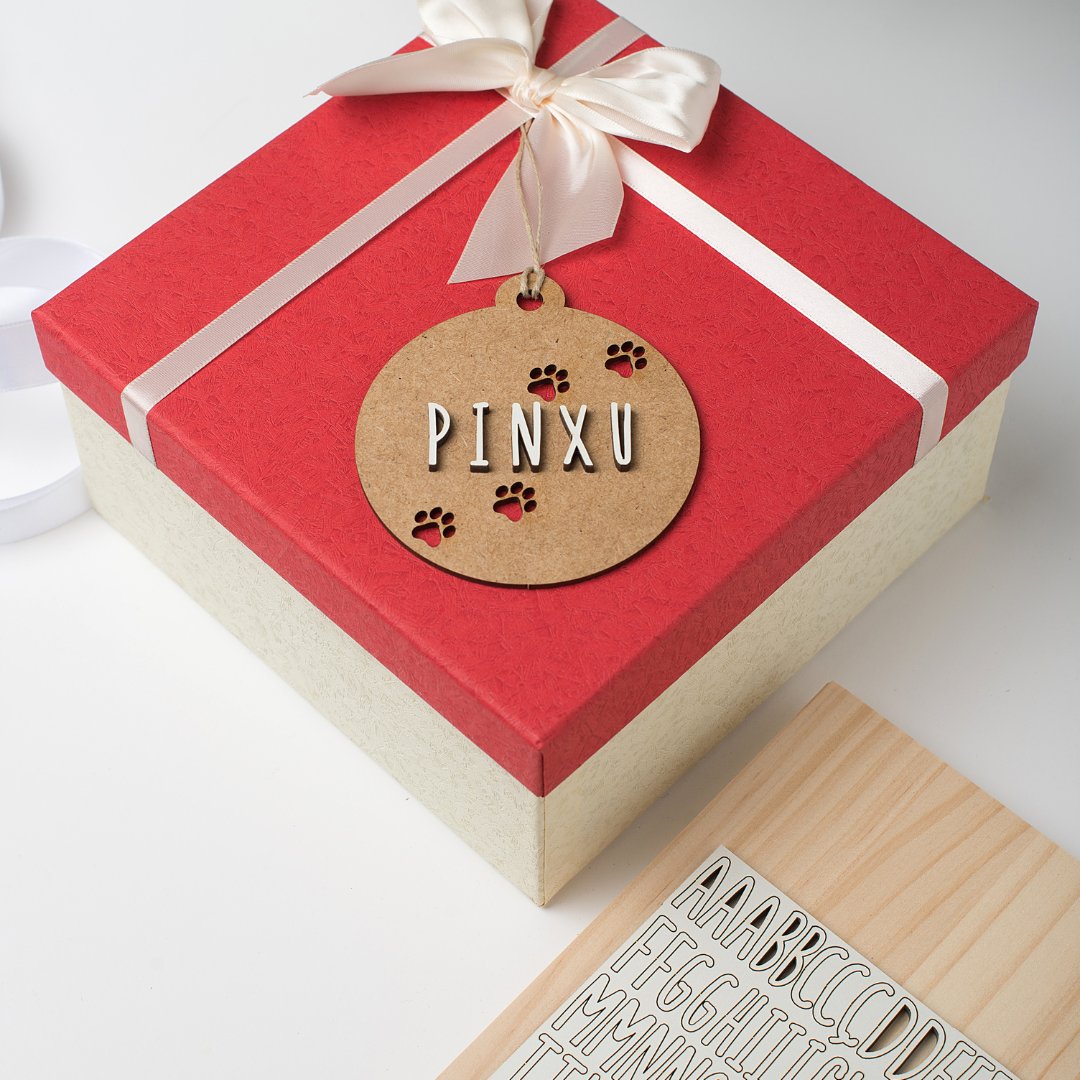 Bolas de Navidad con huellas y nombre colgadas en paquete