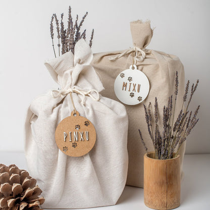 Bolas de Navidad con huellas y nombre colgadas en paquete