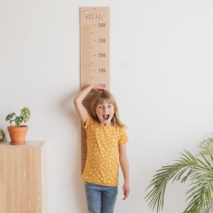 Medidor infantil de madera personalizable con letras adhesivas y flechas para marcar el crecimiento
