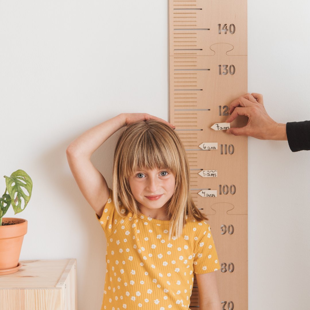 Medidor infantil de madera personalizable con letras adhesivas y flechas para marcar el crecimiento